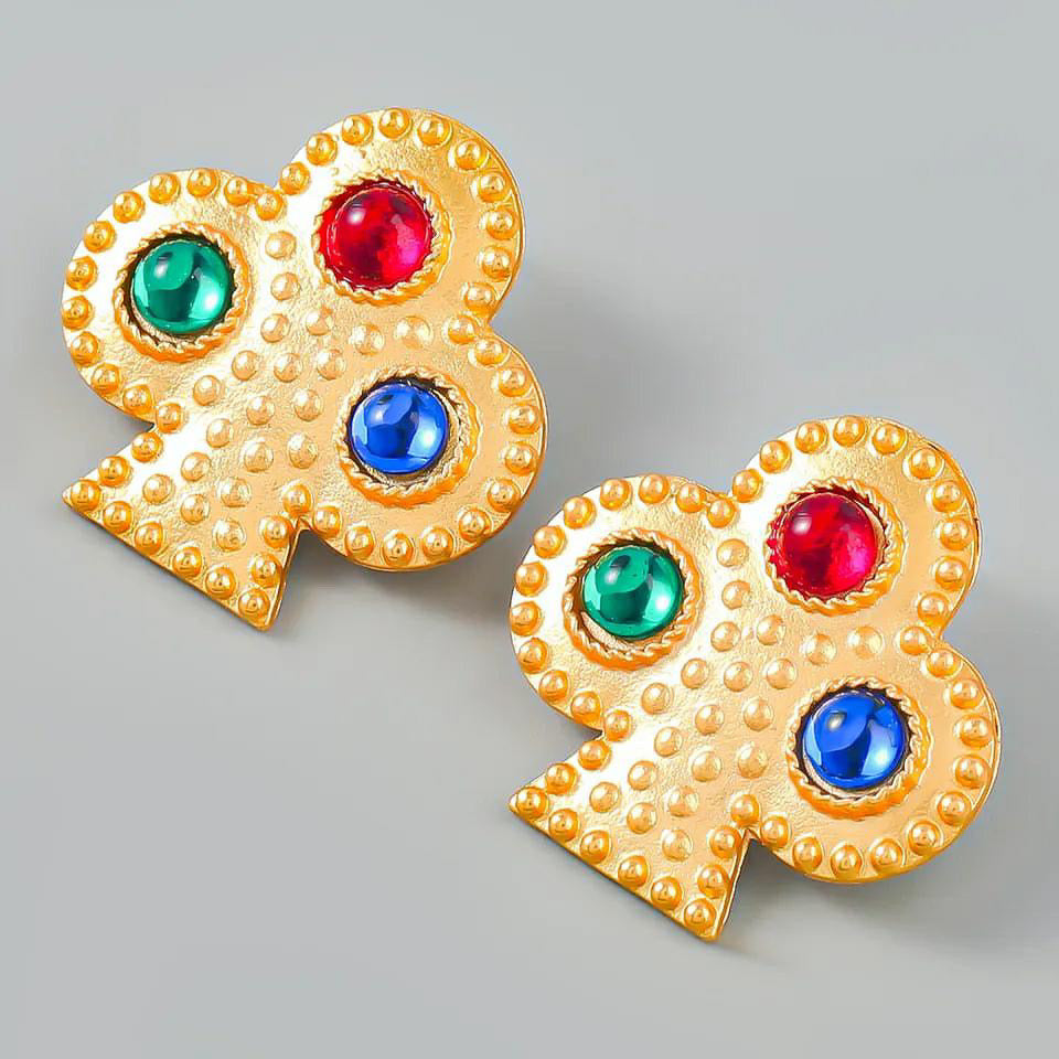 Aretes dorados en forma de trébol de póker con piedras de colores.